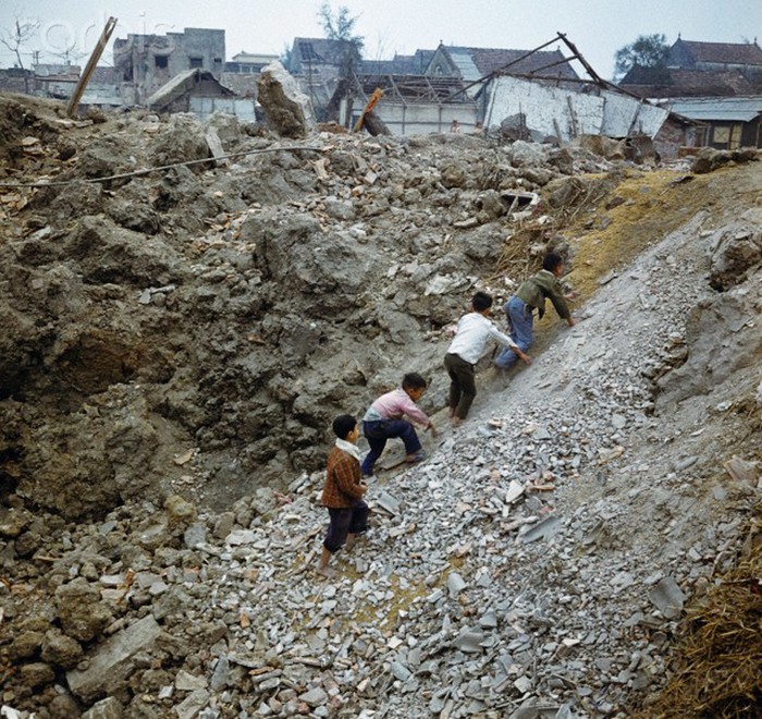 Lũ trẻ chơi đùa cạnh một đống đổ nát do bom Mỹ tấn công tại khu phố Khâm Thiên tháng 12/1973. Ảnh. © Werner Schulze-dpa-Corbis.